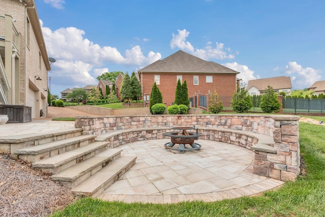 view of patio with an outdoor fire pit and fence