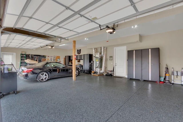 garage featuring a garage door opener and heating unit