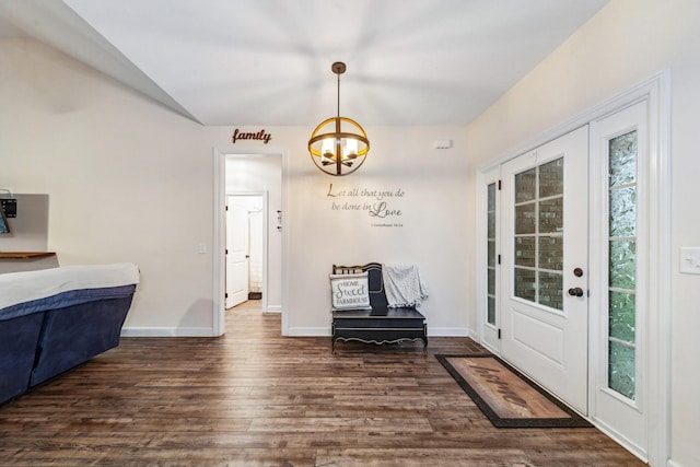 entrance foyer featuring dark wood-style flooring, a notable chandelier, and baseboards