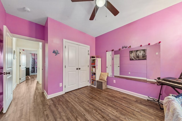 bedroom with ceiling fan, baseboards, a closet, and wood finished floors
