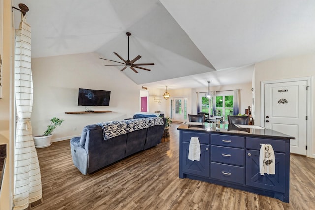 living area with ceiling fan, lofted ceiling, baseboards, and wood finished floors