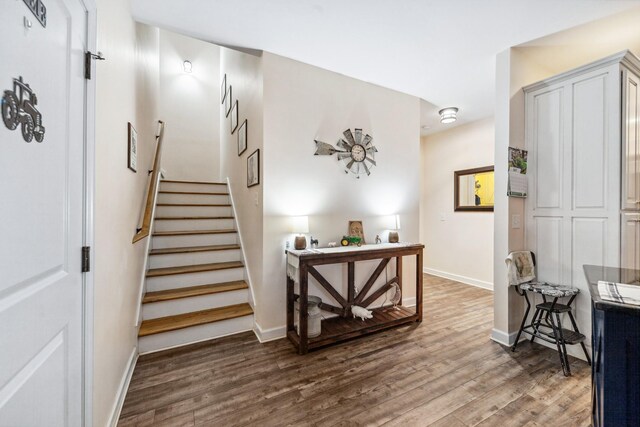 staircase with baseboards and wood finished floors