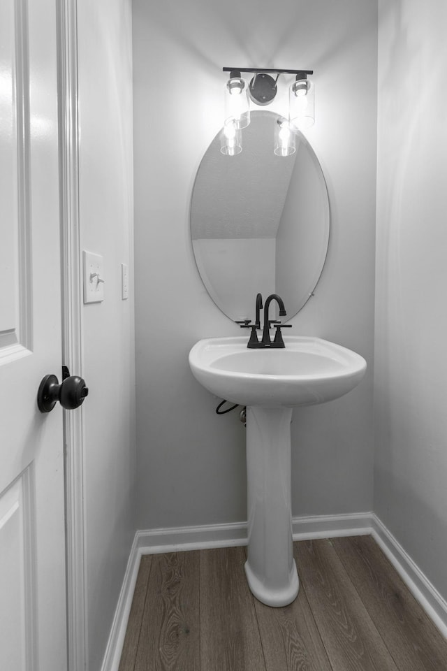 bathroom with baseboards and wood finished floors
