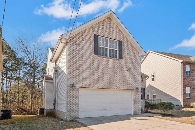view of side of home featuring an attached garage, driveway, brick siding, and cooling unit