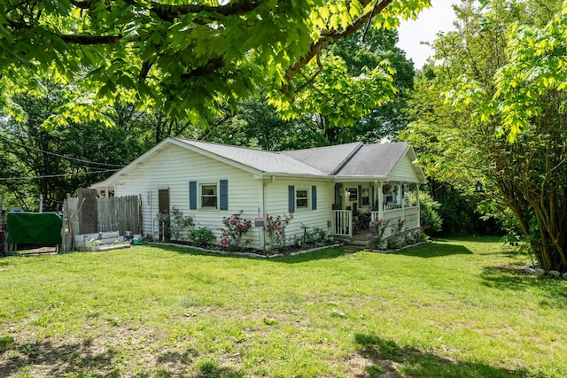 ranch-style house featuring covered porch and a front yard