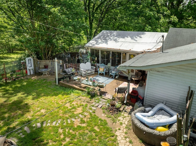 exterior space featuring a sunroom, a wooden deck, and fence