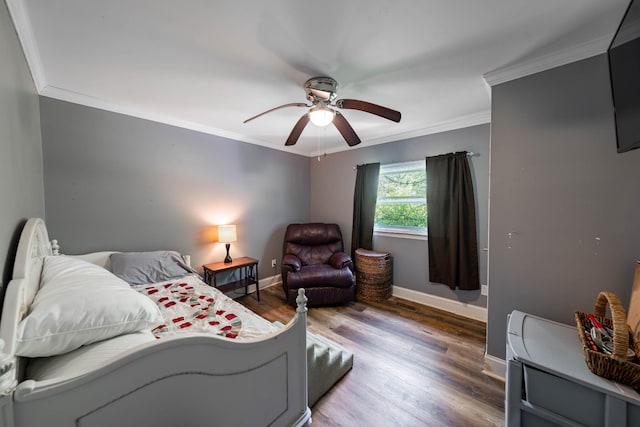 bedroom featuring crown molding, baseboards, a ceiling fan, and wood finished floors
