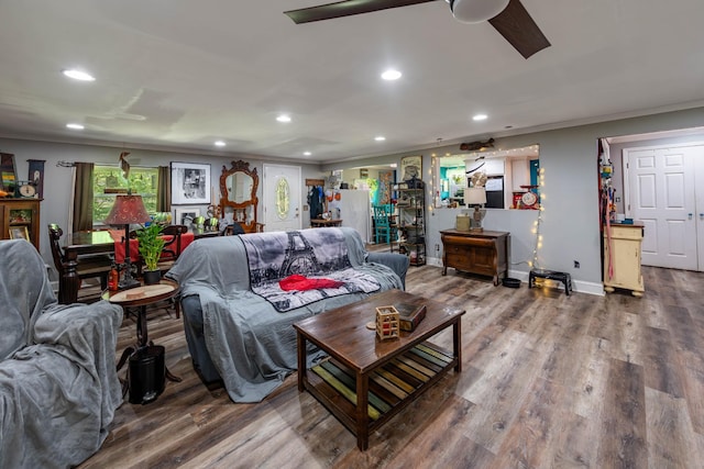 living area featuring baseboards, ornamental molding, recessed lighting, and wood finished floors
