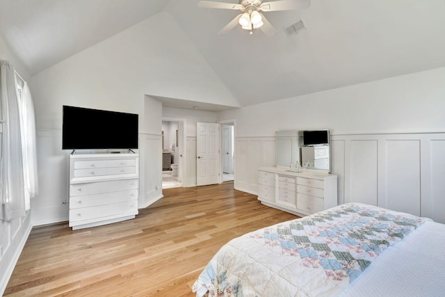 bedroom featuring a ceiling fan, light wood finished floors, visible vents, a decorative wall, and a wainscoted wall