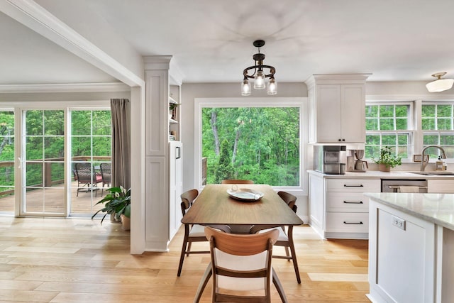 interior space featuring ornamental molding, light wood-style flooring, a wealth of natural light, and a chandelier