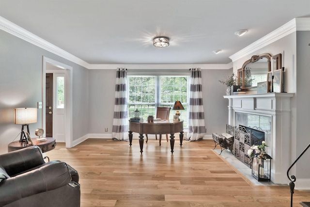 living area featuring light wood finished floors, ornamental molding, and a healthy amount of sunlight