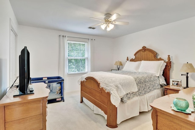 bedroom with light carpet, visible vents, ceiling fan, and a closet