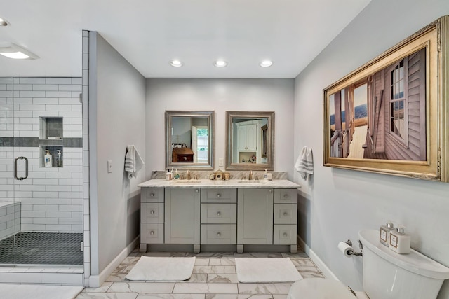 bathroom featuring baseboards, marble finish floor, a sink, and a shower stall
