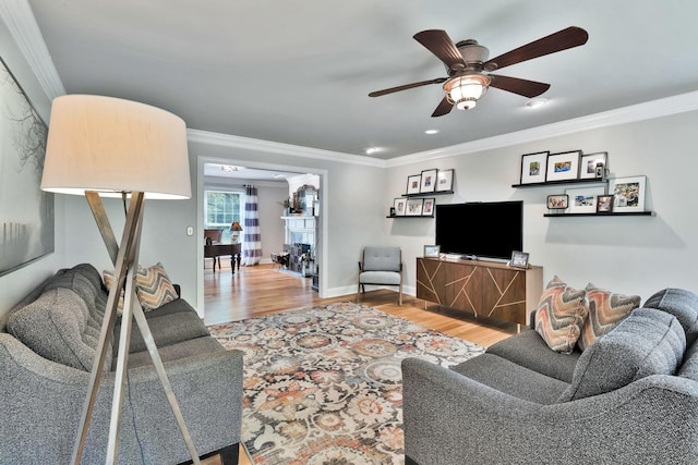 living room with crown molding, wood finished floors, ceiling fan, and recessed lighting