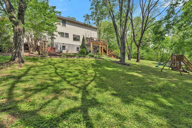view of yard featuring stairway, a wooden deck, and a playground