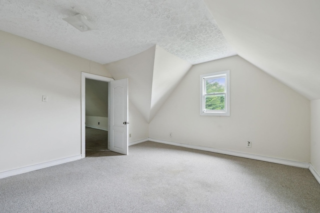 bonus room with carpet floors, a textured ceiling, baseboards, and lofted ceiling