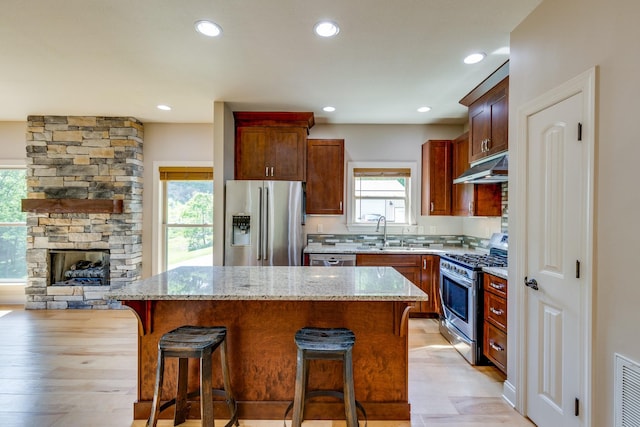 1545 Gravel Hill Rd, Columbia, TN 38401 - kitchen with a kitchen breakfast bar, a kitchen island, appliances with stainless steel finishes, light stone counters, and under cabinet range hood