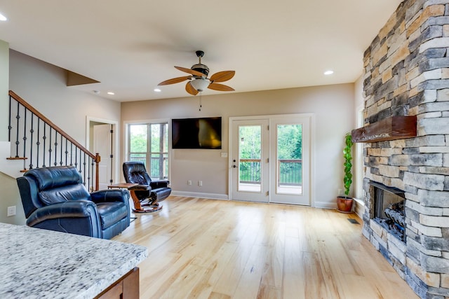 1545 Gravel Hill Rd, Columbia, TN 38401 - living room featuring light wood-style flooring, a ceiling fan, stairs, and a stone fireplace