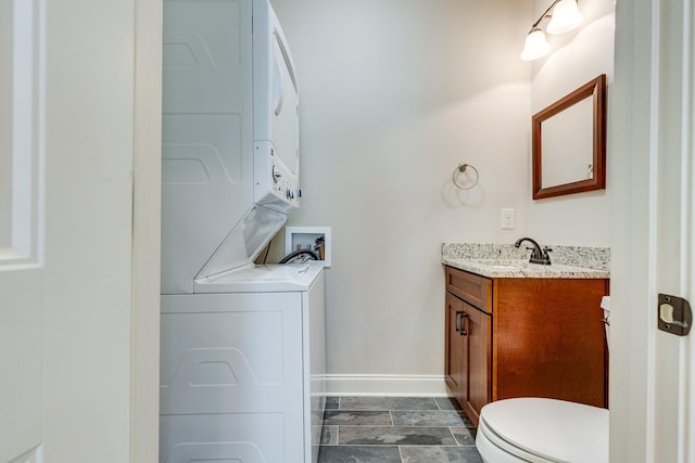 1545 Gravel Hill Rd, Columbia, TN 38401 - bathroom featuring vanity, toilet, baseboards, stacked washing maching and dryer, and stone finish flooring