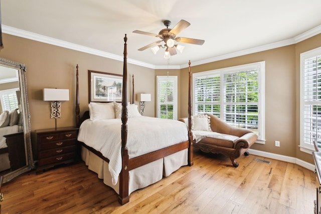 bedroom featuring crown molding, visible vents, multiple windows, and hardwood / wood-style flooring