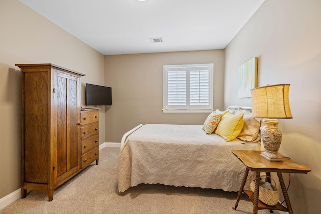 bedroom with baseboards, light carpet, and visible vents