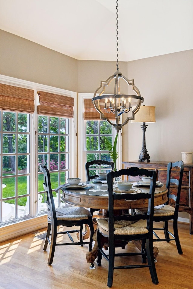 dining space featuring an inviting chandelier, a healthy amount of sunlight, and light wood-style flooring