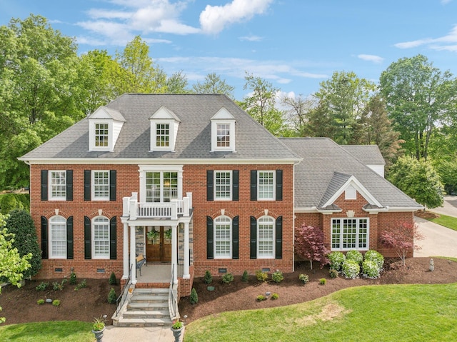 colonial house featuring brick siding, crawl space, and a front lawn