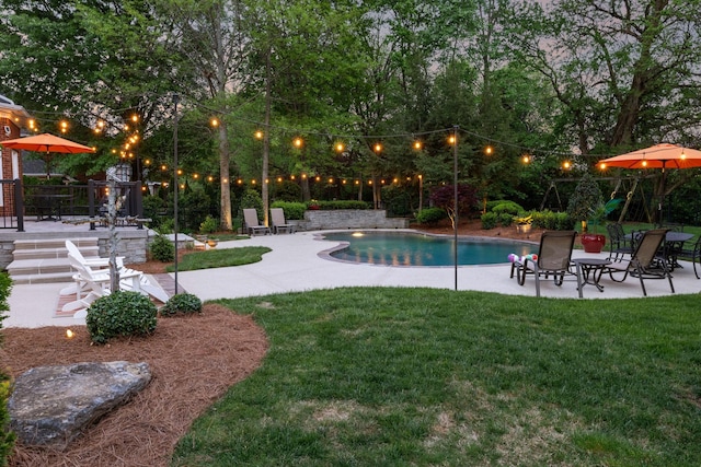 outdoor pool with a lawn and a patio