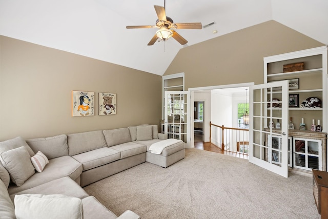 carpeted living room featuring high vaulted ceiling, a ceiling fan, and visible vents