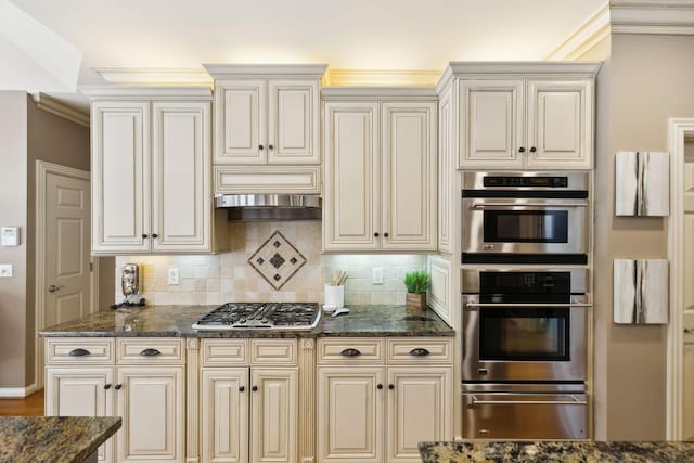 kitchen with cream cabinets, stainless steel appliances, crown molding, and a warming drawer