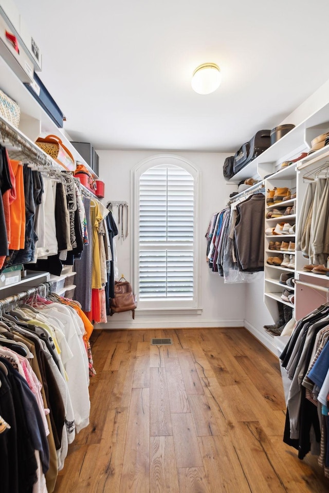 walk in closet with hardwood / wood-style flooring and visible vents