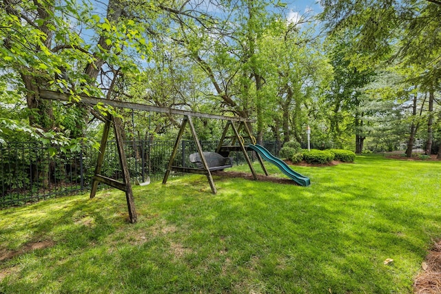 view of playground featuring a lawn and fence