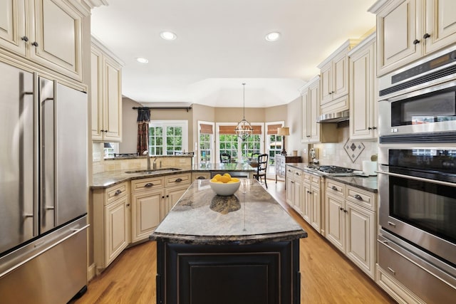 kitchen featuring a sink, appliances with stainless steel finishes, a warming drawer, and cream cabinetry