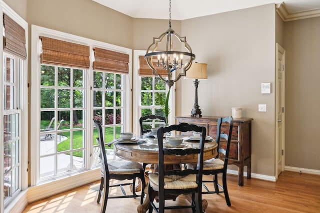 dining space featuring light wood-style floors, baseboards, and a chandelier