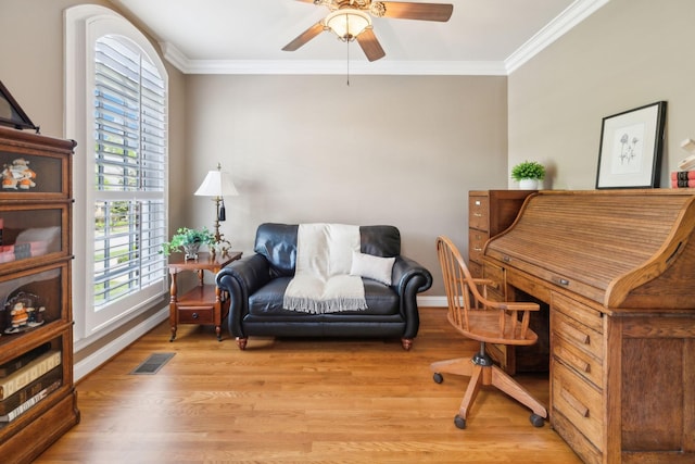 office area featuring ornamental molding, a ceiling fan, light wood finished floors, and visible vents