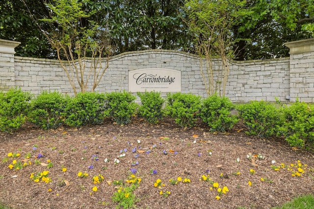 community / neighborhood sign featuring fence