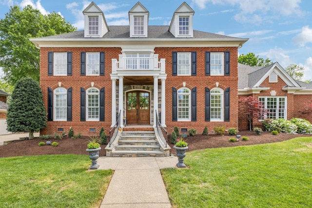 colonial house featuring a front lawn, a balcony, french doors, and crawl space