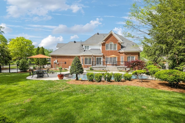 rear view of property featuring fence, a yard, a patio area, and brick siding