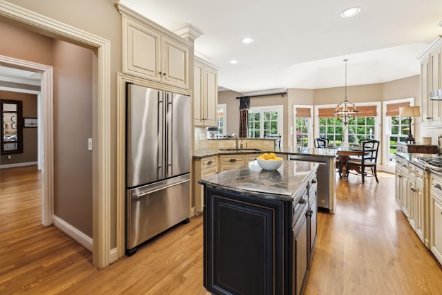 kitchen featuring a sink, appliances with stainless steel finishes, cream cabinetry, and a peninsula