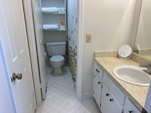 bathroom with vanity, tile patterned flooring, and toilet