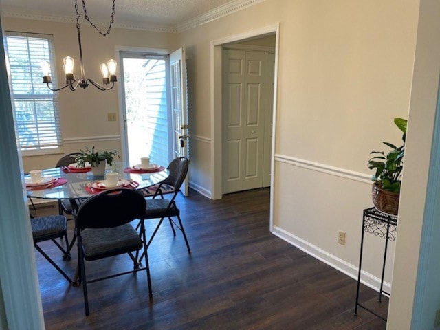 dining room with ornamental molding, dark wood finished floors, a chandelier, and a wealth of natural light