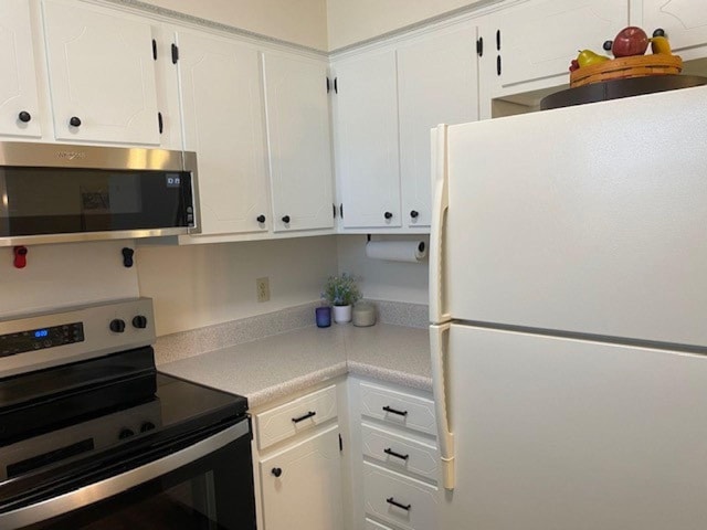 kitchen featuring light countertops, appliances with stainless steel finishes, and white cabinetry