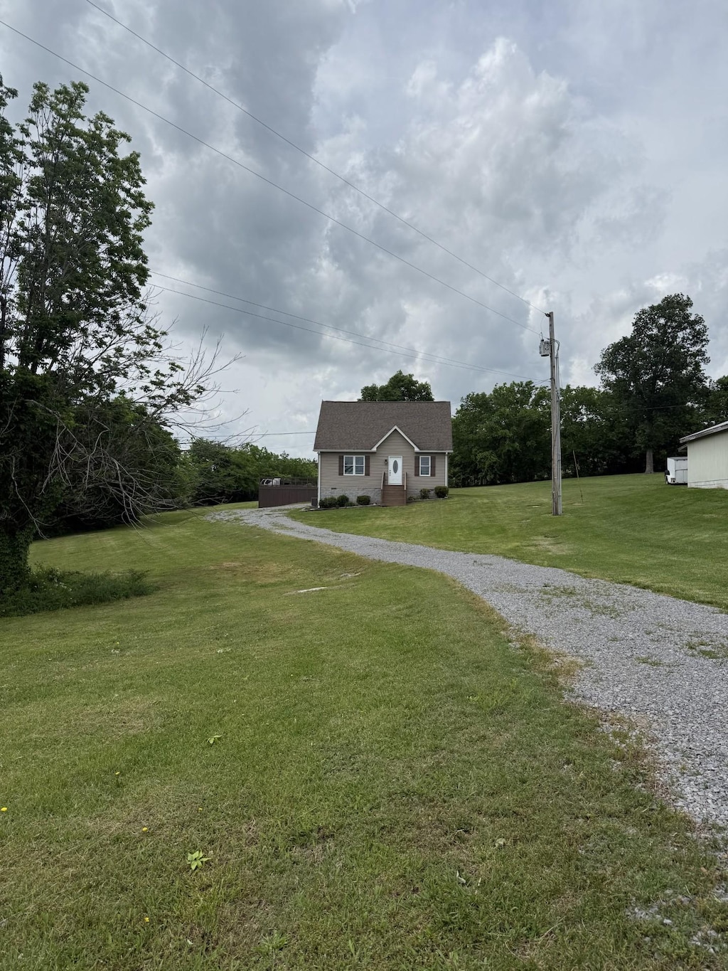 view of front facade with a front yard and gravel driveway