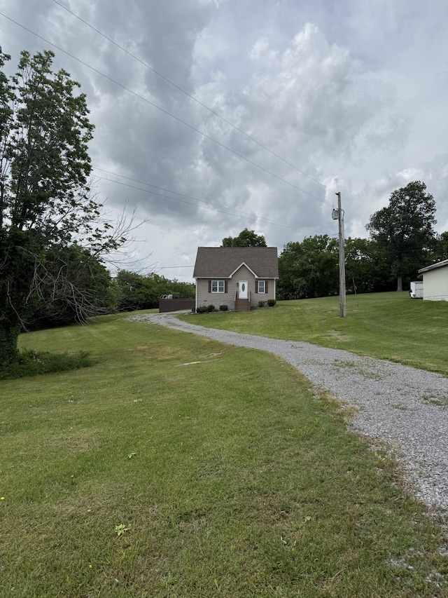 view of front facade with a front yard and gravel driveway