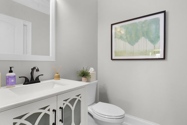 half bathroom with vanity and toilet