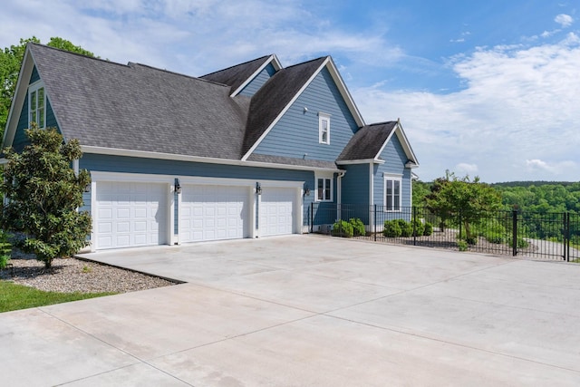 view of front of property with fence, a shingled roof, an attached garage, and driveway