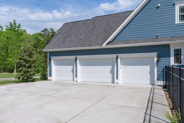 garage featuring fence and driveway