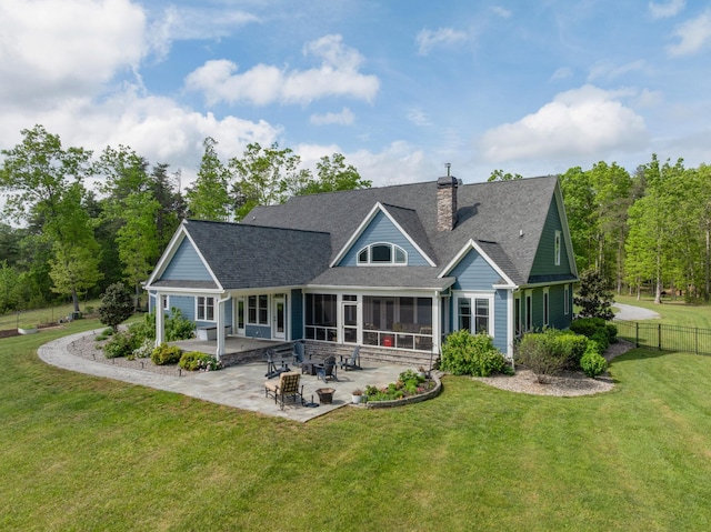 back of house with fence, a sunroom, a chimney, a patio, and a yard