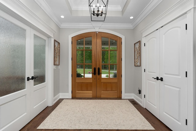 entryway with an inviting chandelier, french doors, and dark wood-style floors