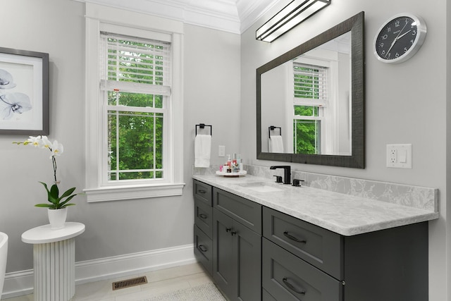 bathroom with crown molding, baseboards, plenty of natural light, and visible vents